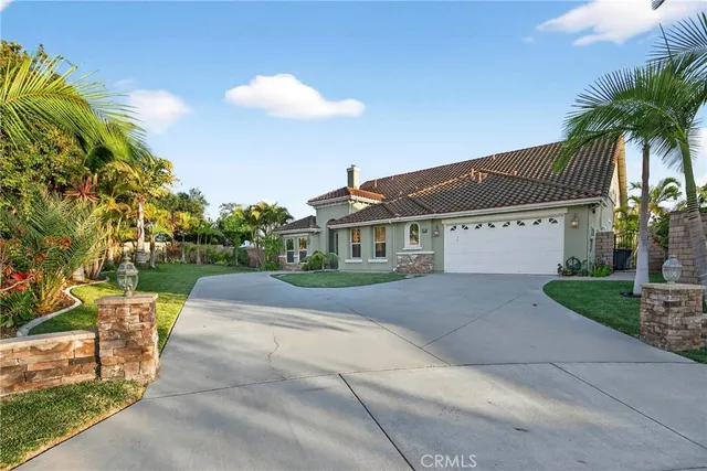 a front view of a house with a yard and potted plants