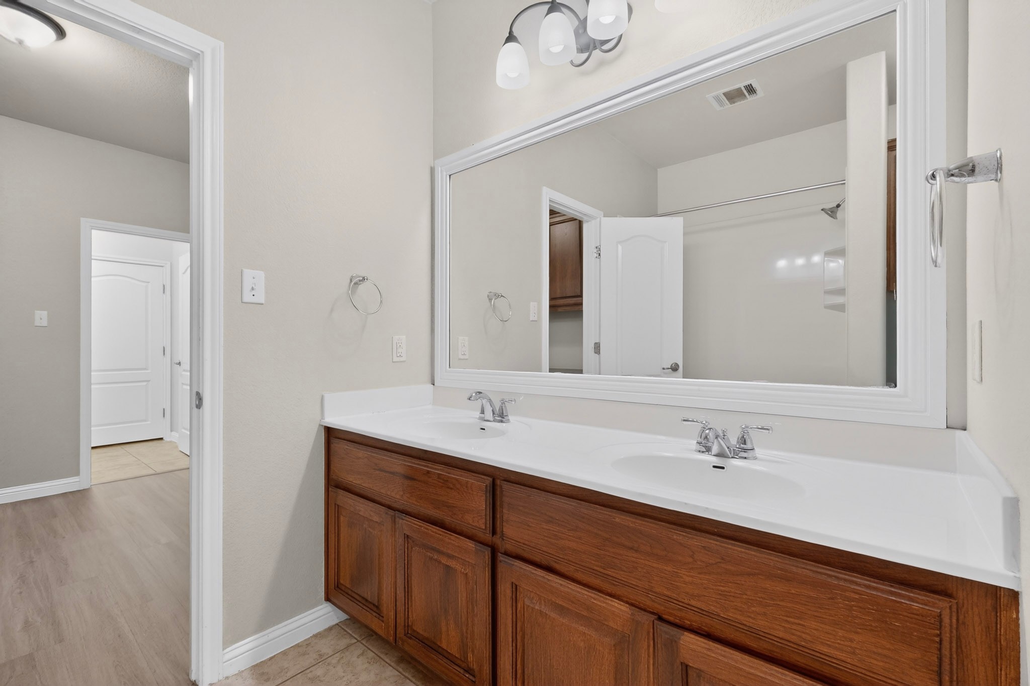 178 Limestone Trail Austin, TX 78737 - Photo 28 of 40 Double vanity with integrated sinks, white countertop, and wood-finish cabinetry