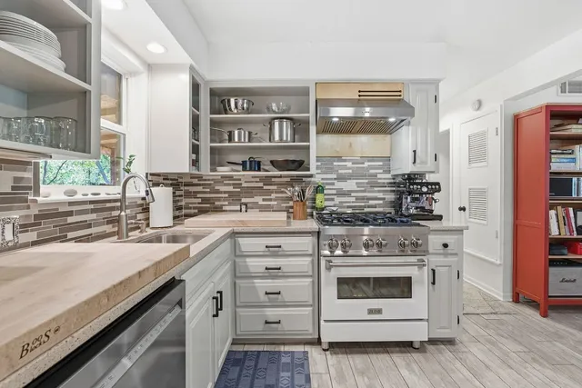 a kitchen with stainless steel appliances granite countertop a stove and cabinets