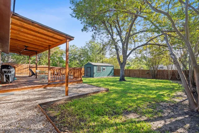 a view of a backyard with table and chairs under an umbrella