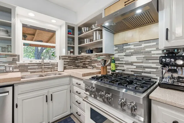 a kitchen with stainless steel appliances granite countertop a stove and a sink