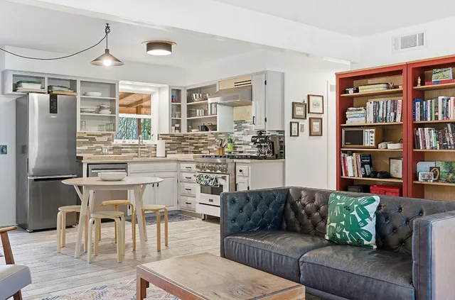 a living room with furniture and a kitchen view