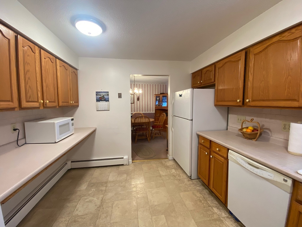 155 Ponakin Road Lancaster, MA 01523 - Photo 3 of 19 a kitchen with a refrigerator a sink and cabinets