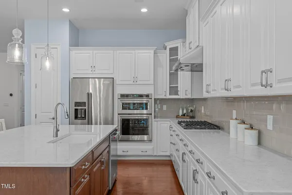 a kitchen with stainless steel appliances granite countertop a sink stove and refrigerator