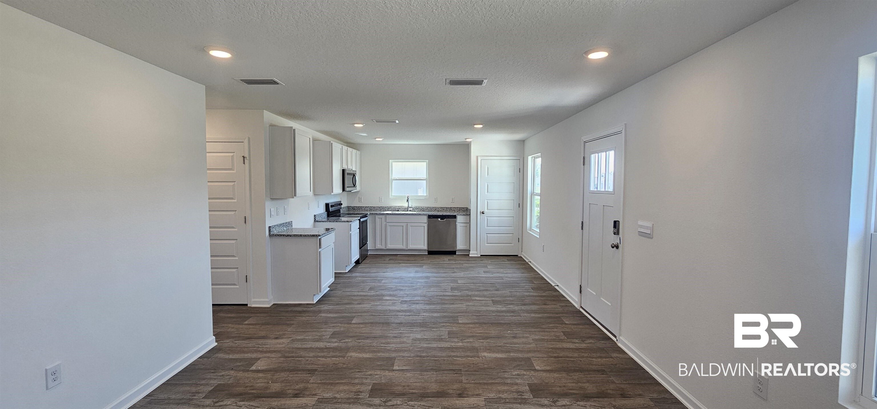 1152 Sweet Laurel Street Foley, AL 36535 - Photo 3 of 4 Kitchen with sink, a textured ceiling, white cabinetry, appliances with stainless steel finishes, and dark hardwood / wood-style flooring