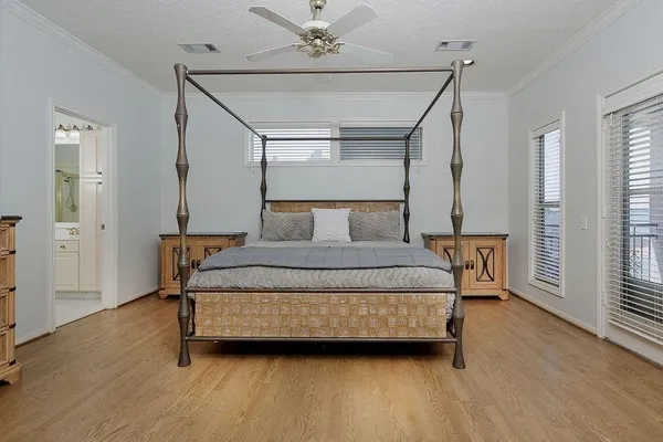 a bedroom with a bed wooden floor and window