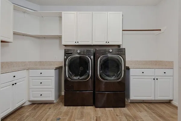 a utility room with cabinets dryer and washer
