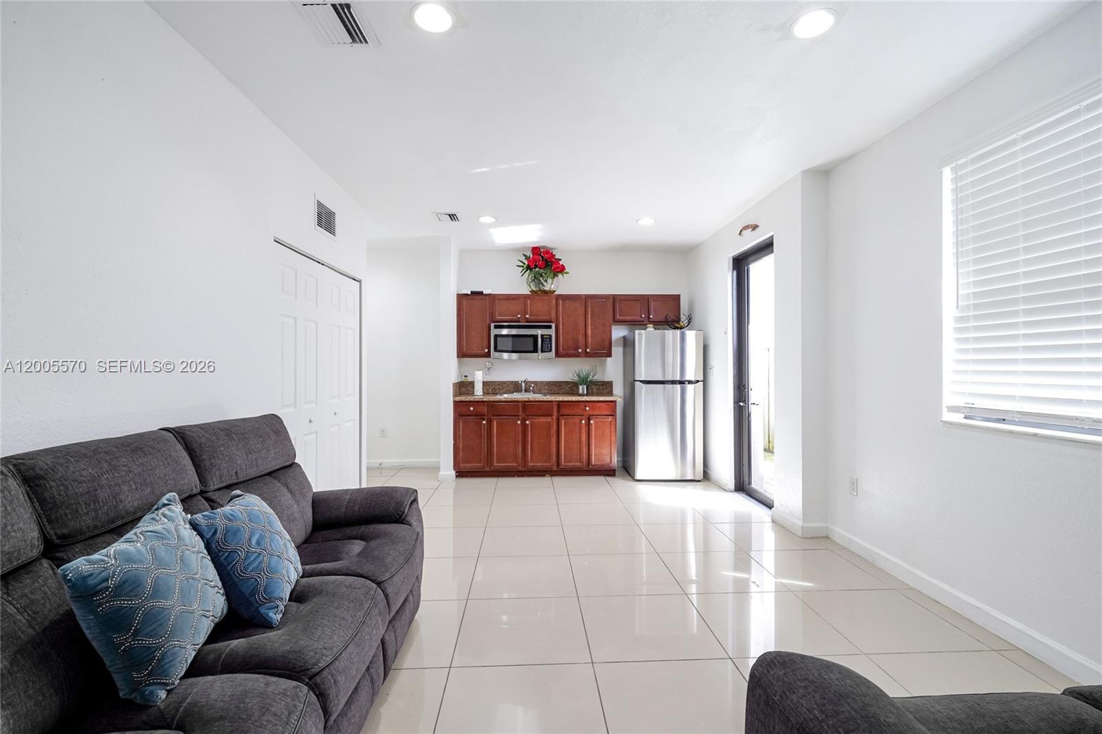 15294 Southwest 173rd Street Miami, FL 33187 - Photo 11 of 48 a living room with furniture and kitchen view
