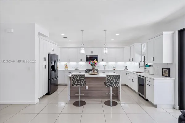 a kitchen with stainless steel appliances kitchen island granite countertop a sink and cabinets