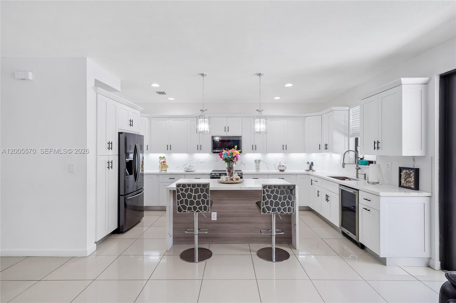 15294 Southwest 173rd Street Miami, FL 33187 - Photo 15 of 48 a kitchen with stainless steel appliances kitchen island granite countertop a refrigerator and a stove top oven