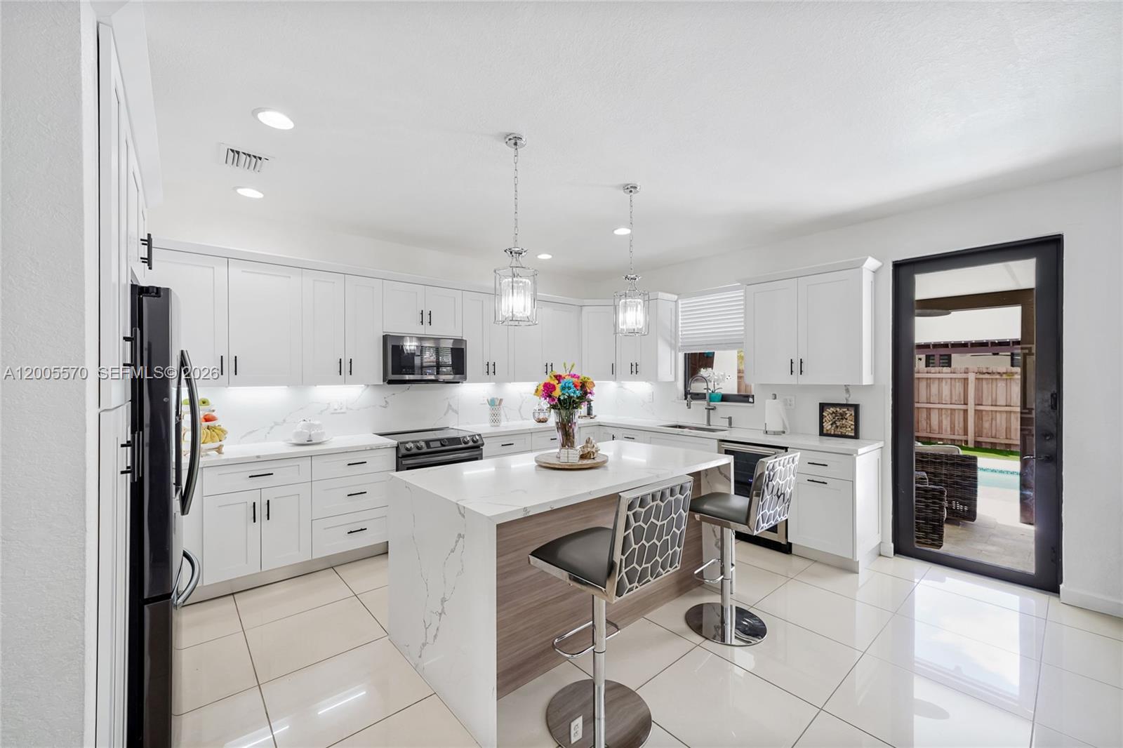 15294 Southwest 173rd Street Miami, FL 33187 - Photo 16 of 48 a kitchen with stainless steel appliances kitchen island granite countertop a sink and cabinets