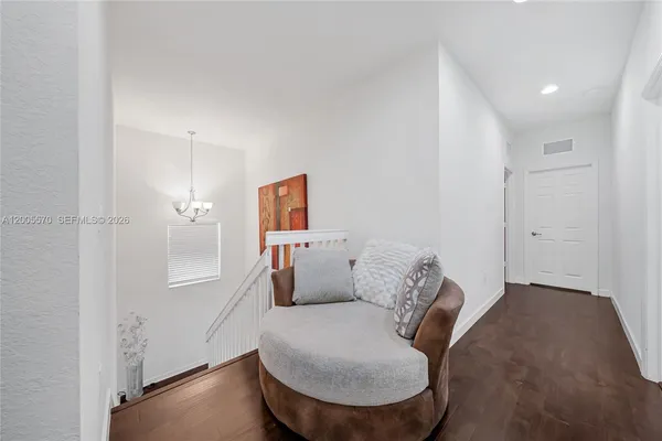 a bedroom with a bed chandelier and a window
