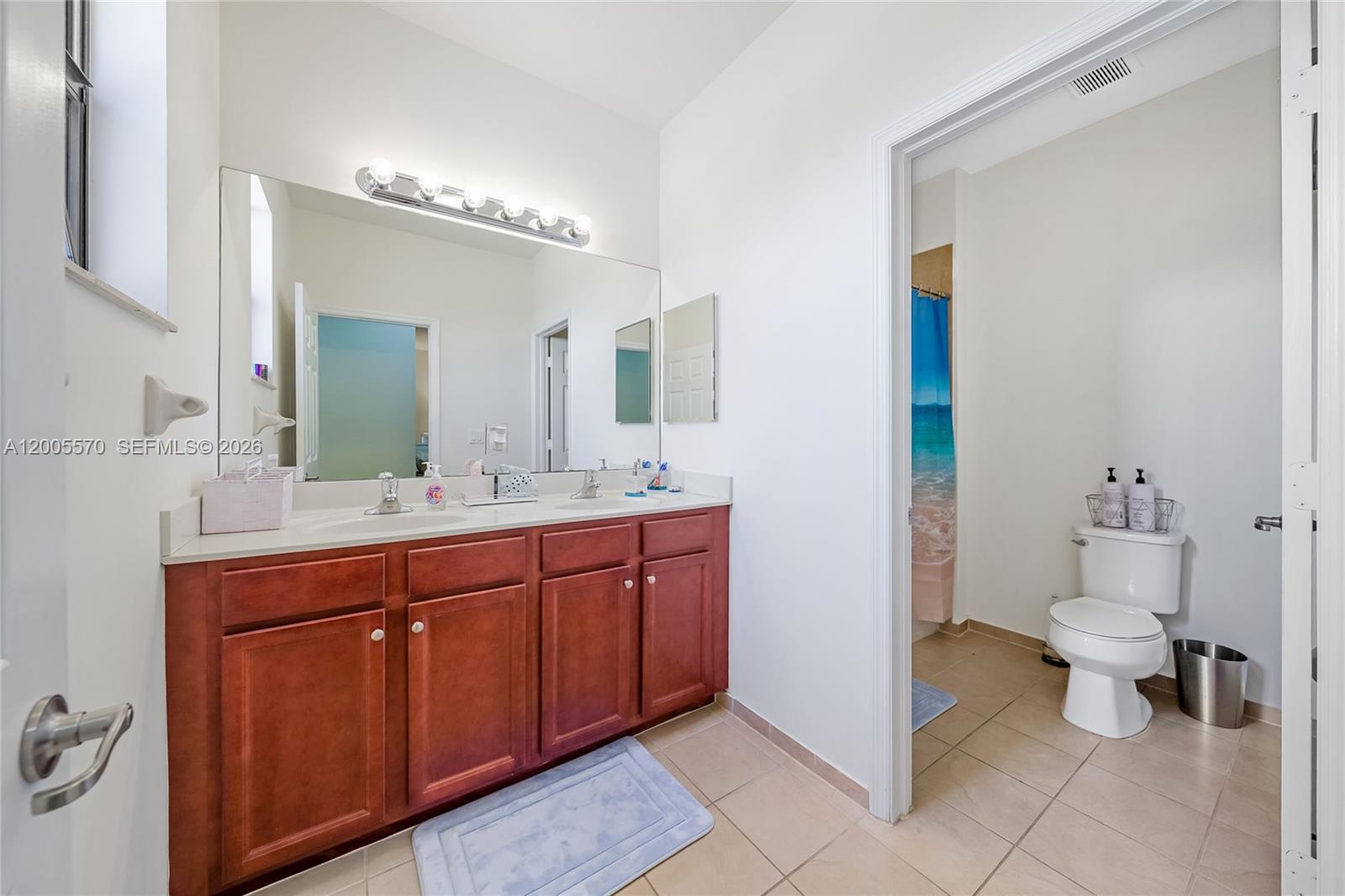 15294 Southwest 173rd Street Miami, FL 33187 - Photo 28 of 48 a spacious bathroom with a double vanity sink a toilet and a mirror