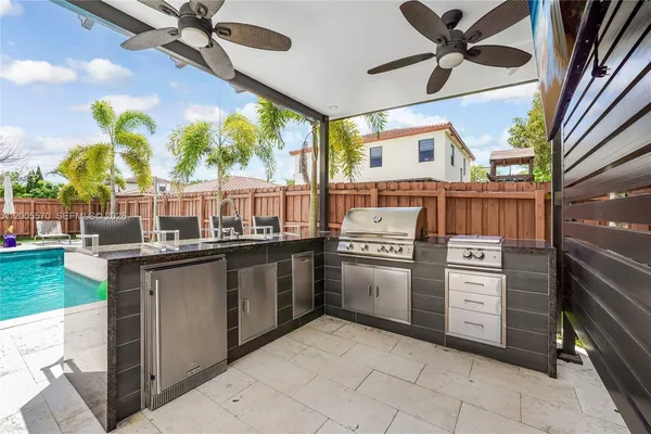 a view of a patio with a table and chairs and wooden fence