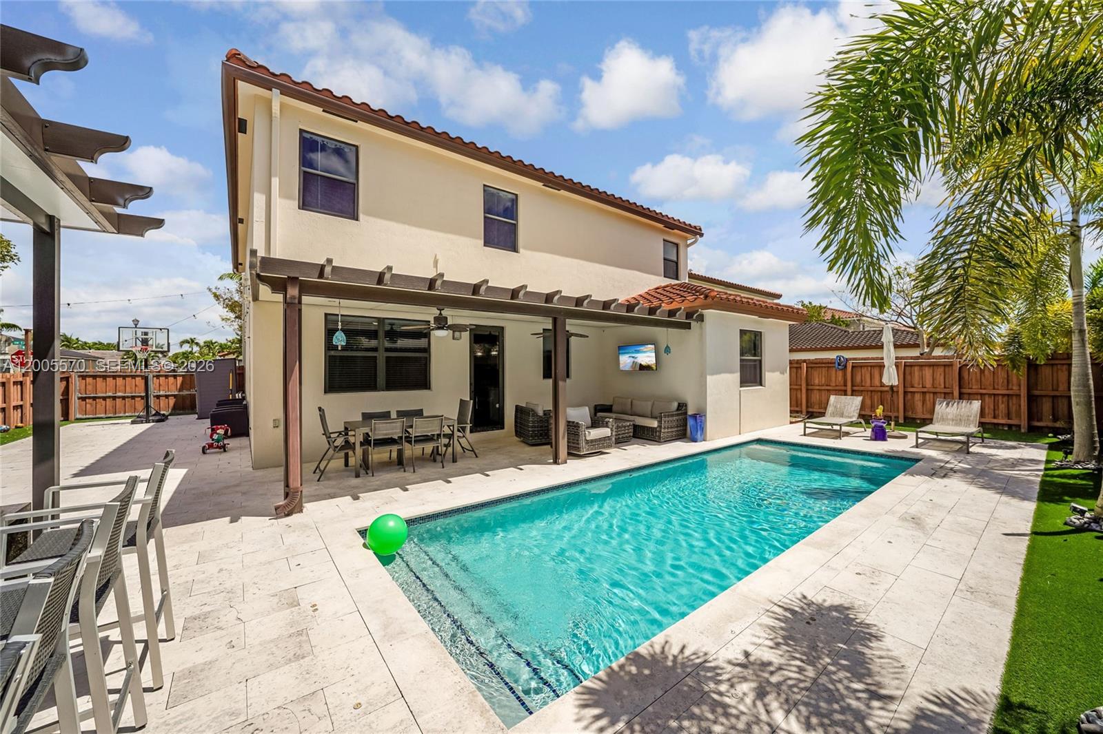 15294 Southwest 173rd Street Miami, FL 33187 - Photo 38 of 48 a view of a house with backyard sitting area and swimming pool