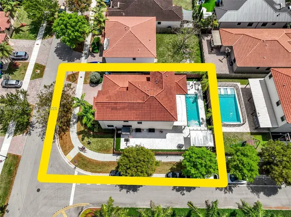 an aerial view of a swimming pool with outdoor seating and yard