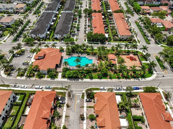 an aerial view of residential houses with outdoor space and trees