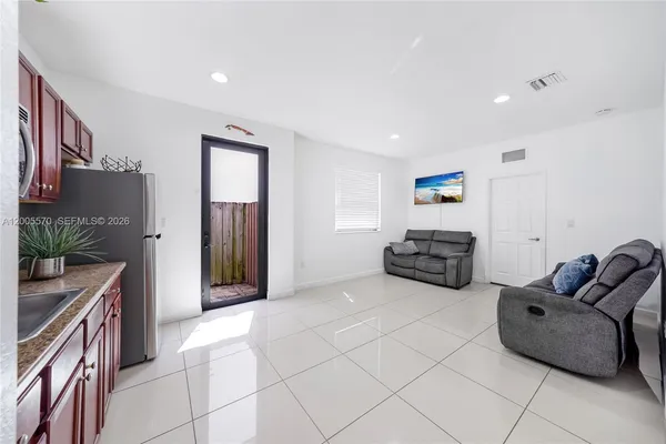 a living room with furniture and kitchen view