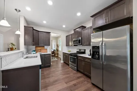 a kitchen with kitchen island a counter top space stainless steel appliances and cabinets