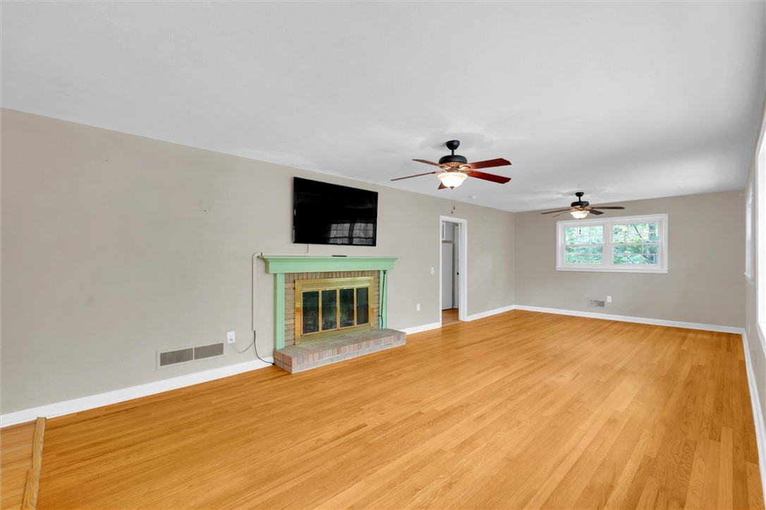 106 Mitchell Avenue Clemson, SC 29631 - Photo 3 of 31 This living room features gleaming hardwood floors and a classic brick fireplace.