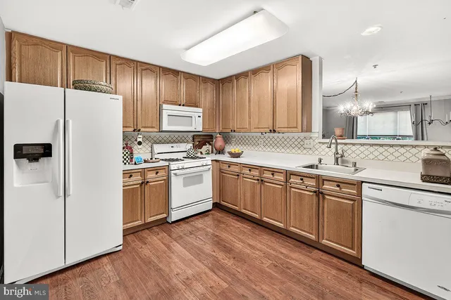 a kitchen with granite countertop white cabinets and white appliances
