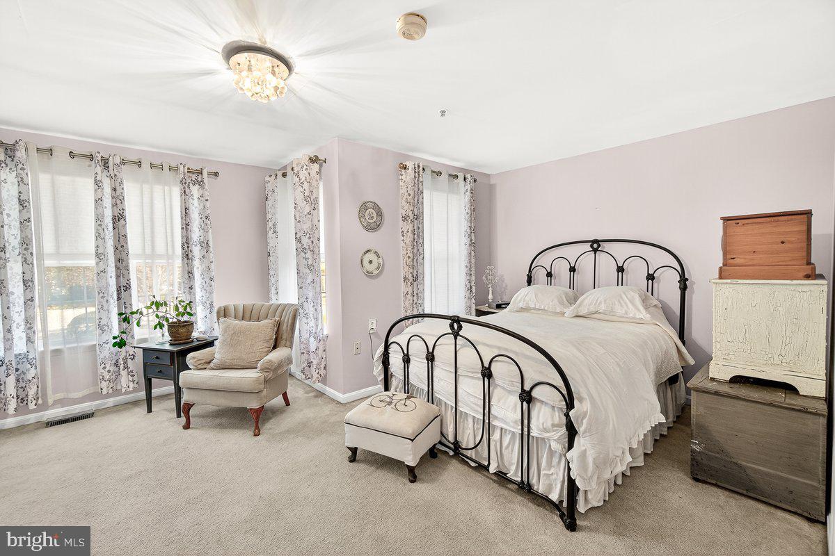 2663 South Everly Drive, Unit 75 Frederick, MD 21701 - Photo 19 of 39 a bedroom with a bed and a chandelier
