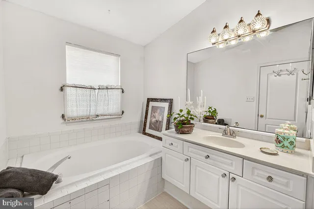 a bathroom with a tub a sink and mirror