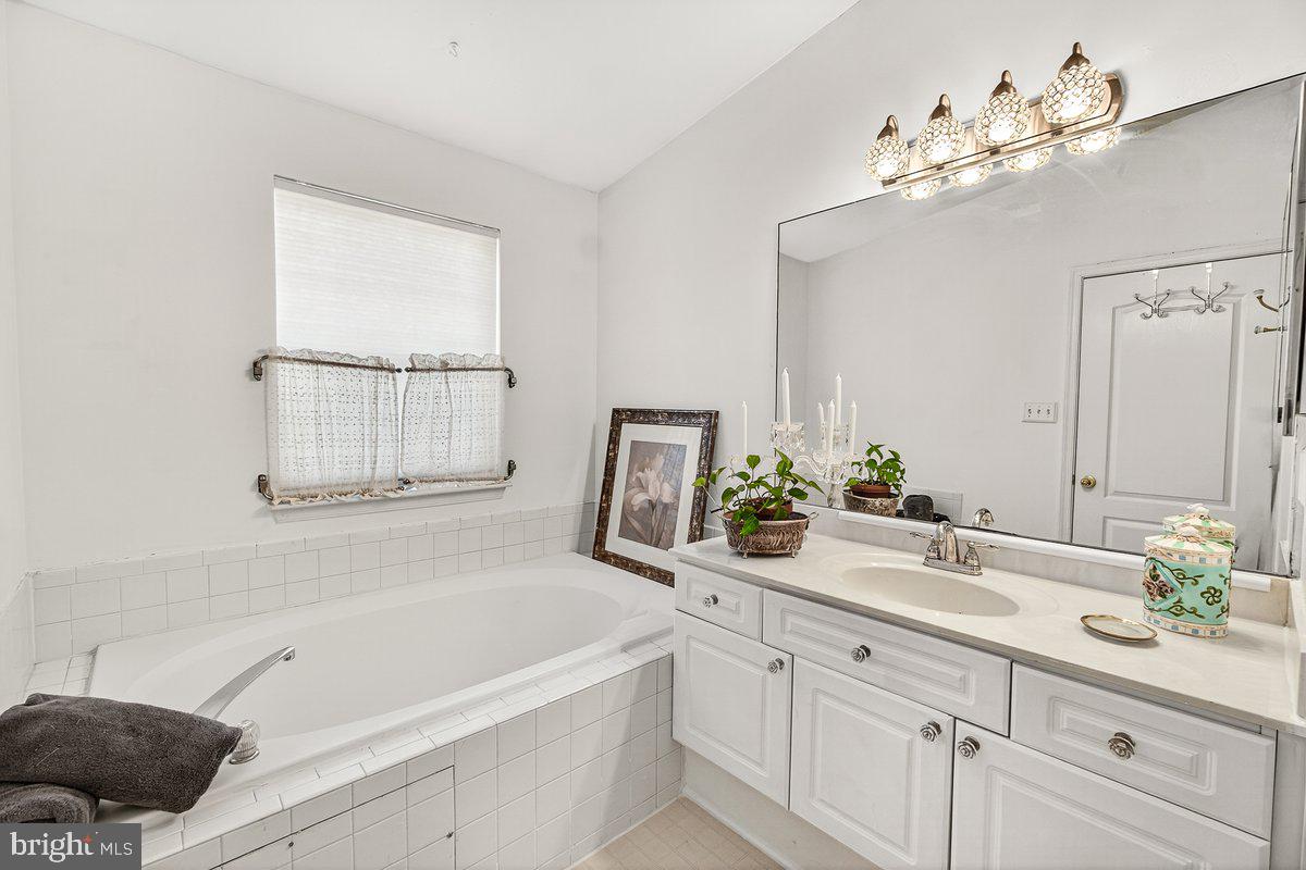 2663 South Everly Drive, Unit 75 Frederick, MD 21701 - Photo 28 of 39 a bathroom with a tub a sink and mirror