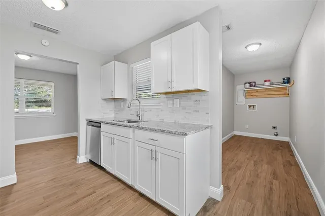 a kitchen with a sink cabinets and wooden floor