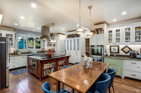 a kitchen with stainless steel appliances a stove a sink dishwasher and cabinets with wooden floor