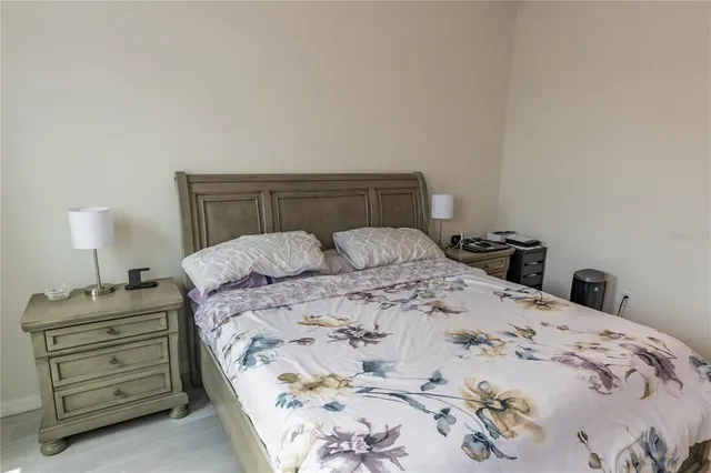 a bedroom with a bed and a lamp on dresser