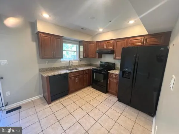 a kitchen with stainless steel appliances granite countertop a refrigerator sink and cabinets