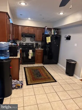 a kitchen with stainless steel appliances granite countertop a refrigerator a stove and a sink