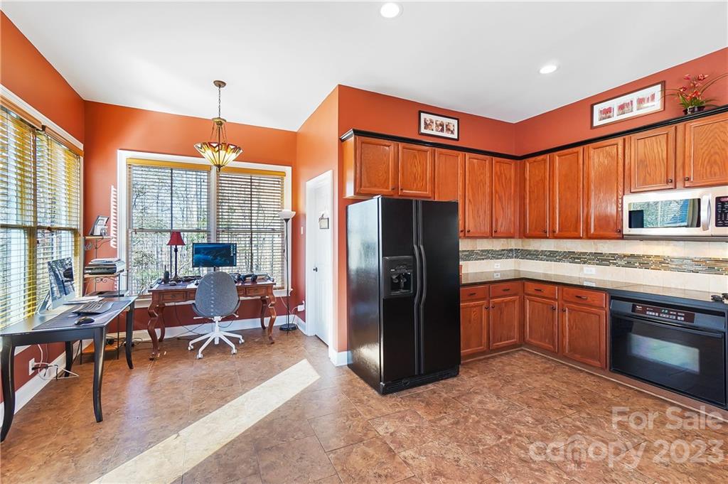 2557 Lower Assembly Drive Fort Mill, SC 29708 - Photo 16 of 32 a kitchen with stainless steel appliances granite countertop a refrigerator a oven a sink dishwasher and wooden cabinets with a large window