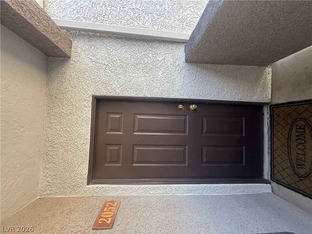 7255 West Sunset Road, Unit 2052 Las Vegas, NV 89113 - Photo 2 of 16 A welcoming entry, with durable stucco walls surrounding a robust paneled door.