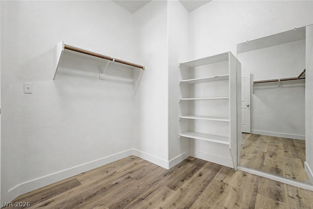 835 Entrada Ridge Avenue Henderson, NV 89012 - Photo 19 of 34 Functional shelving and hanging space define this walk-in closet, complemented by practical wood-look flooring.