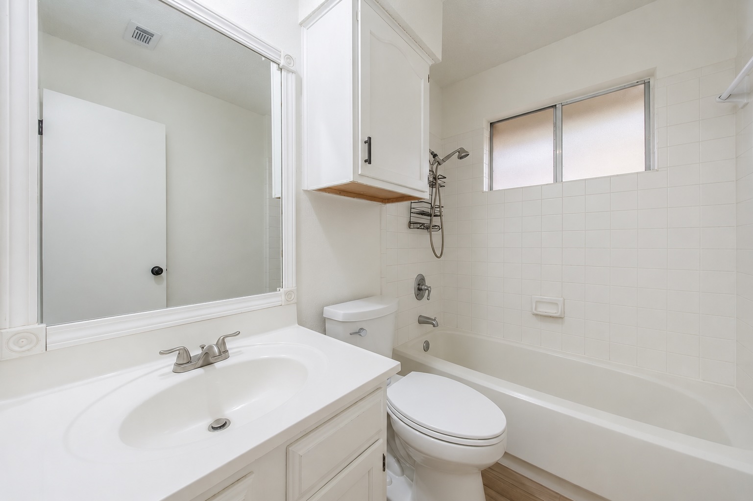 4504 Langtry Lane Austin, TX 78749 - Photo 20 of 24 A well-appointed bathroom offers a clean vanity, mirrored cabinet, and a tiled shower-tub combination.