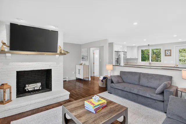 a living room with furniture a flat screen tv and a fireplace