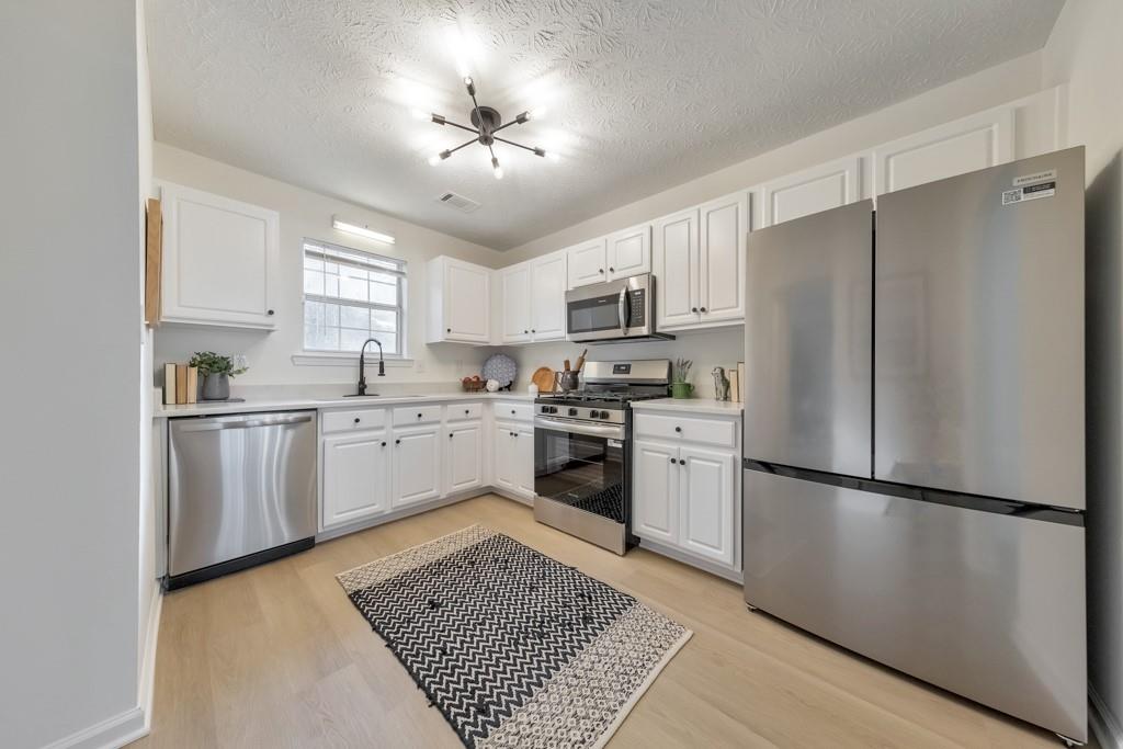 334 Fallview Drive McDonough, GA 30253 - Photo 12 of 34 a kitchen with white cabinets stainless steel appliances and window