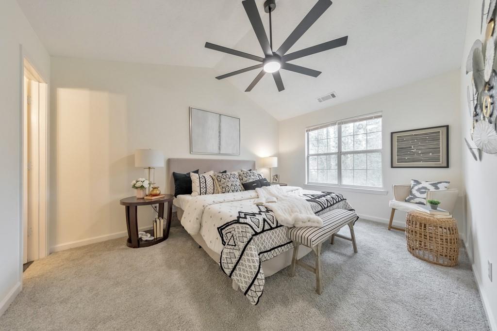 334 Fallview Drive McDonough, GA 30253 - Photo 18 of 34 a bedroom with a bed a chandelier and a couch