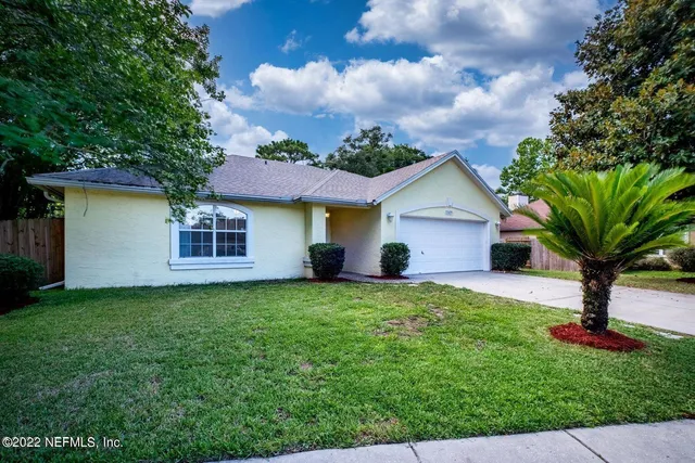 a front view of a house with a yard and a garage