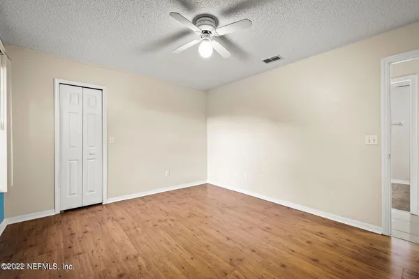 a view of a big room with wooden floor and a ceiling fan