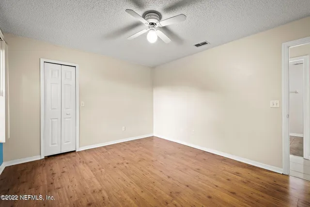 a view of a big room with wooden floor and a ceiling fan