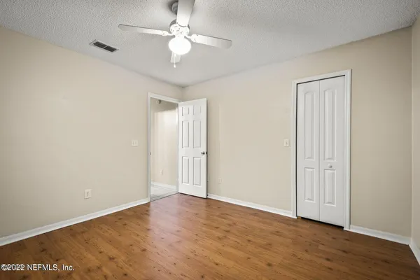 a view of an empty room with wooden floor