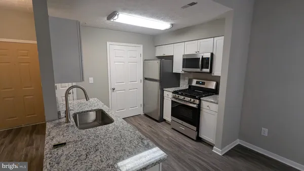 a kitchen with stainless steel appliances granite countertop a stove a sink and a refrigerator