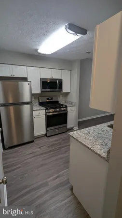 a kitchen with stainless steel appliances granite countertop a stove a refrigerator and a microwave