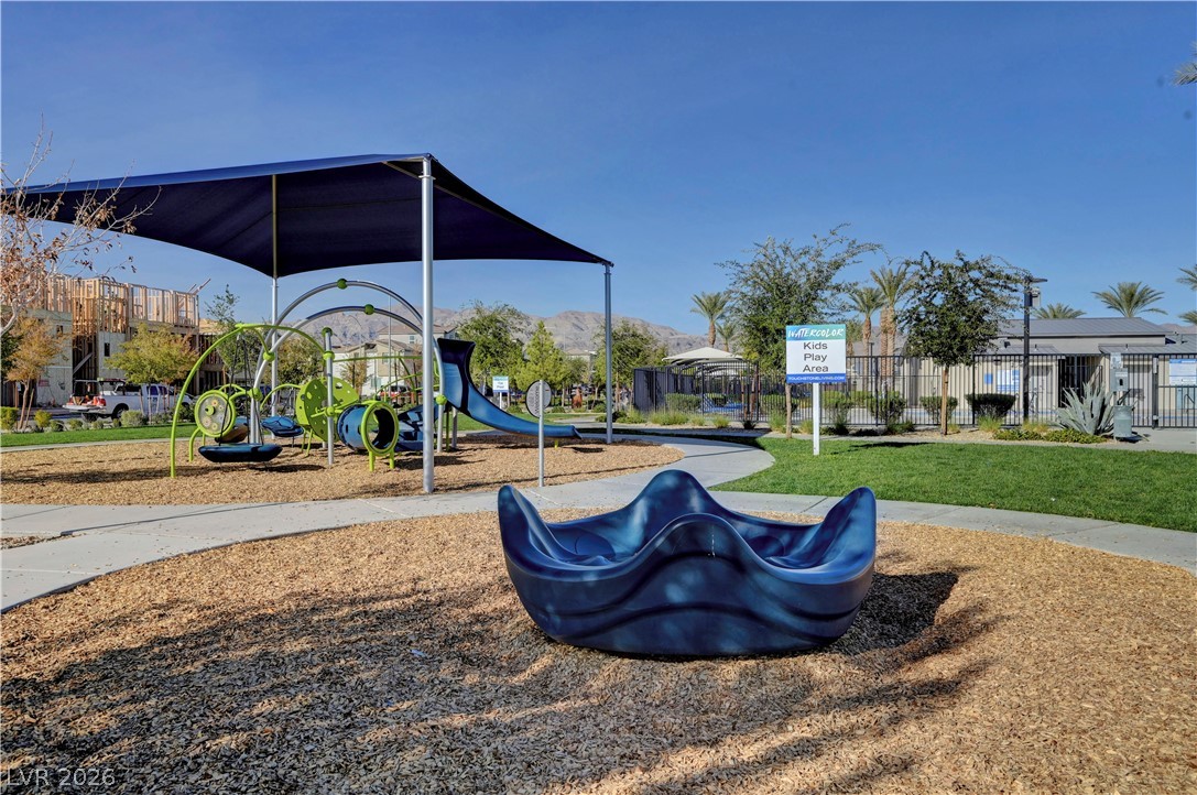 6924 Spicy Merlot Street North Las Vegas, NV 89086 - Photo 72 of 83 A well-maintained children's play area with slides and swings under a protective shade structure.