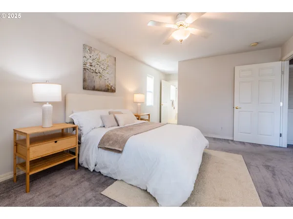 a spacious bedroom with a bed and a lamp