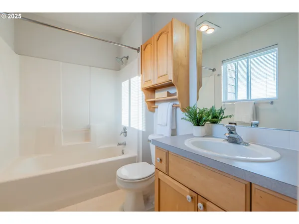 a bathroom with a sink a toilet a tub and shower