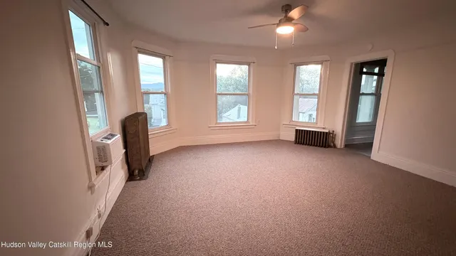 an empty room with windows and closet